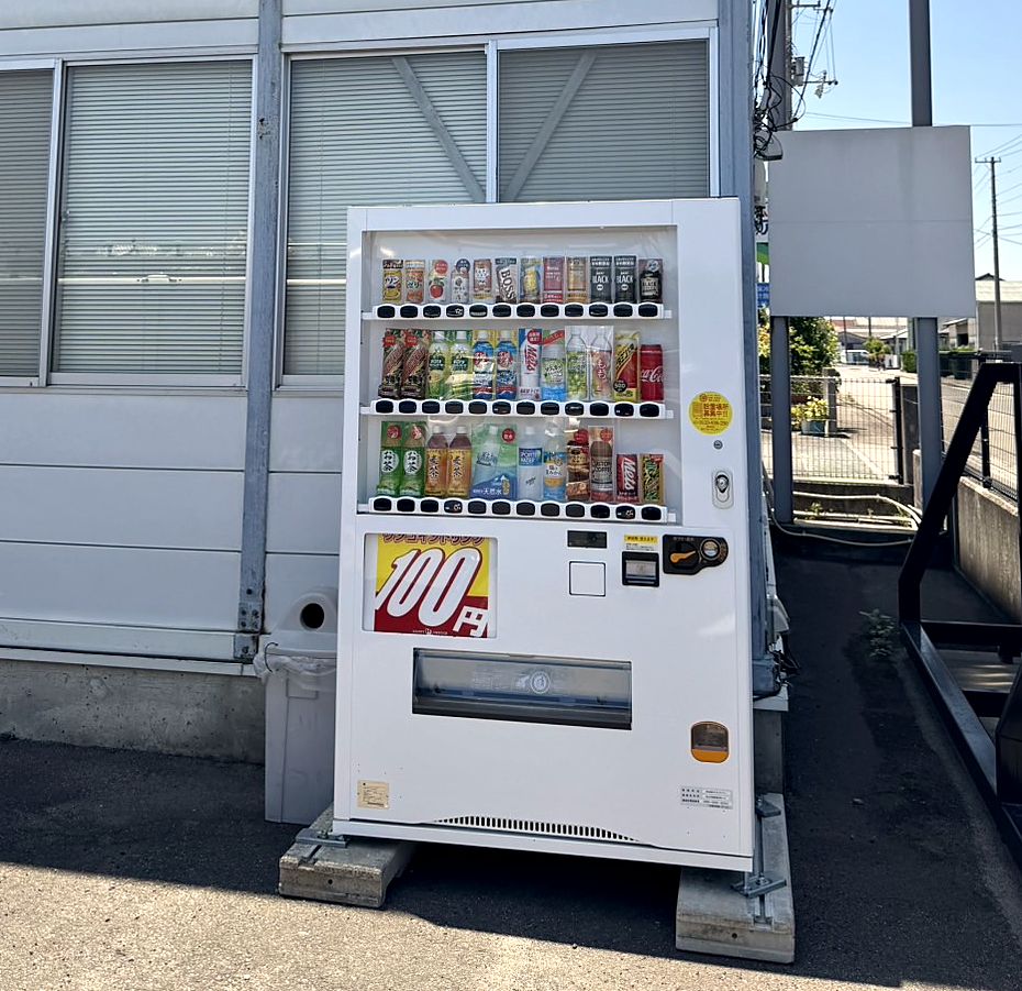 工場の外壁沿いに設置された100円自動販売機