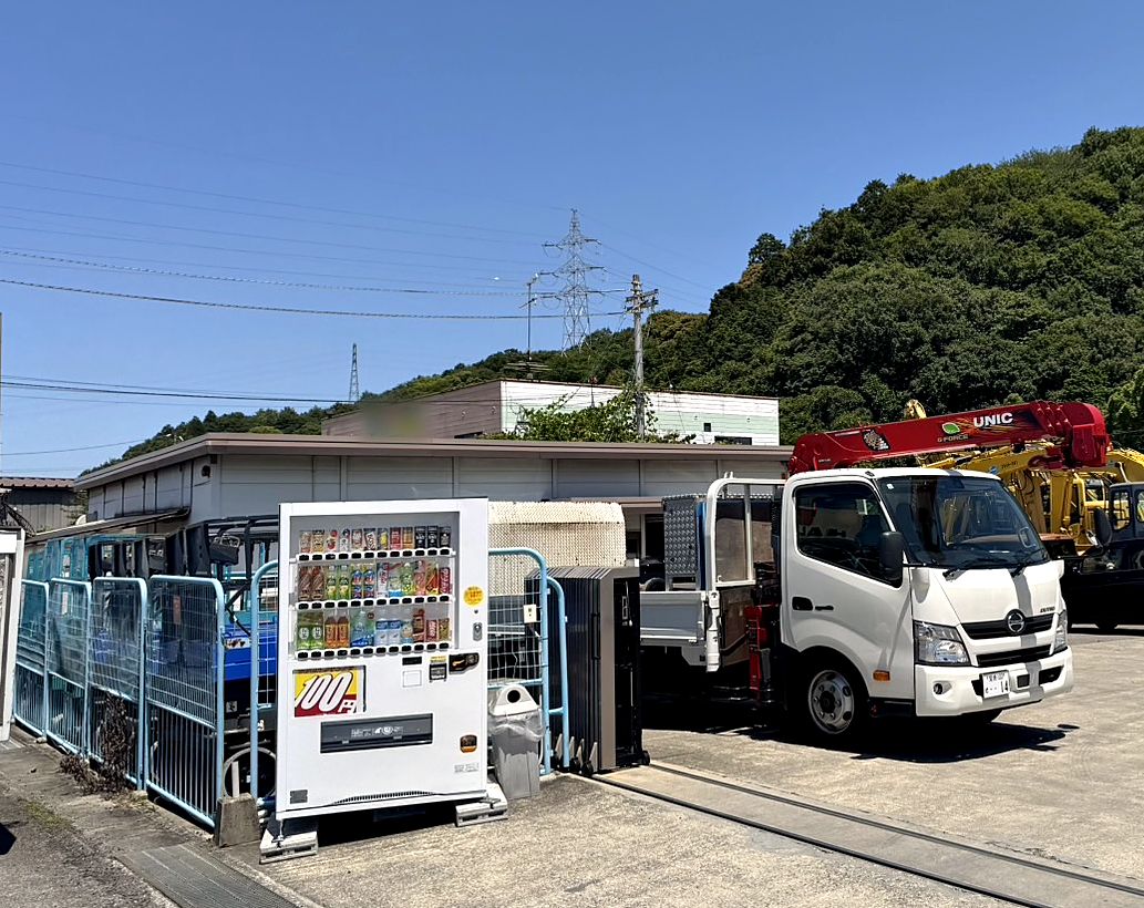 重機が並ぶ資材置き場に設置された100円自動販売機